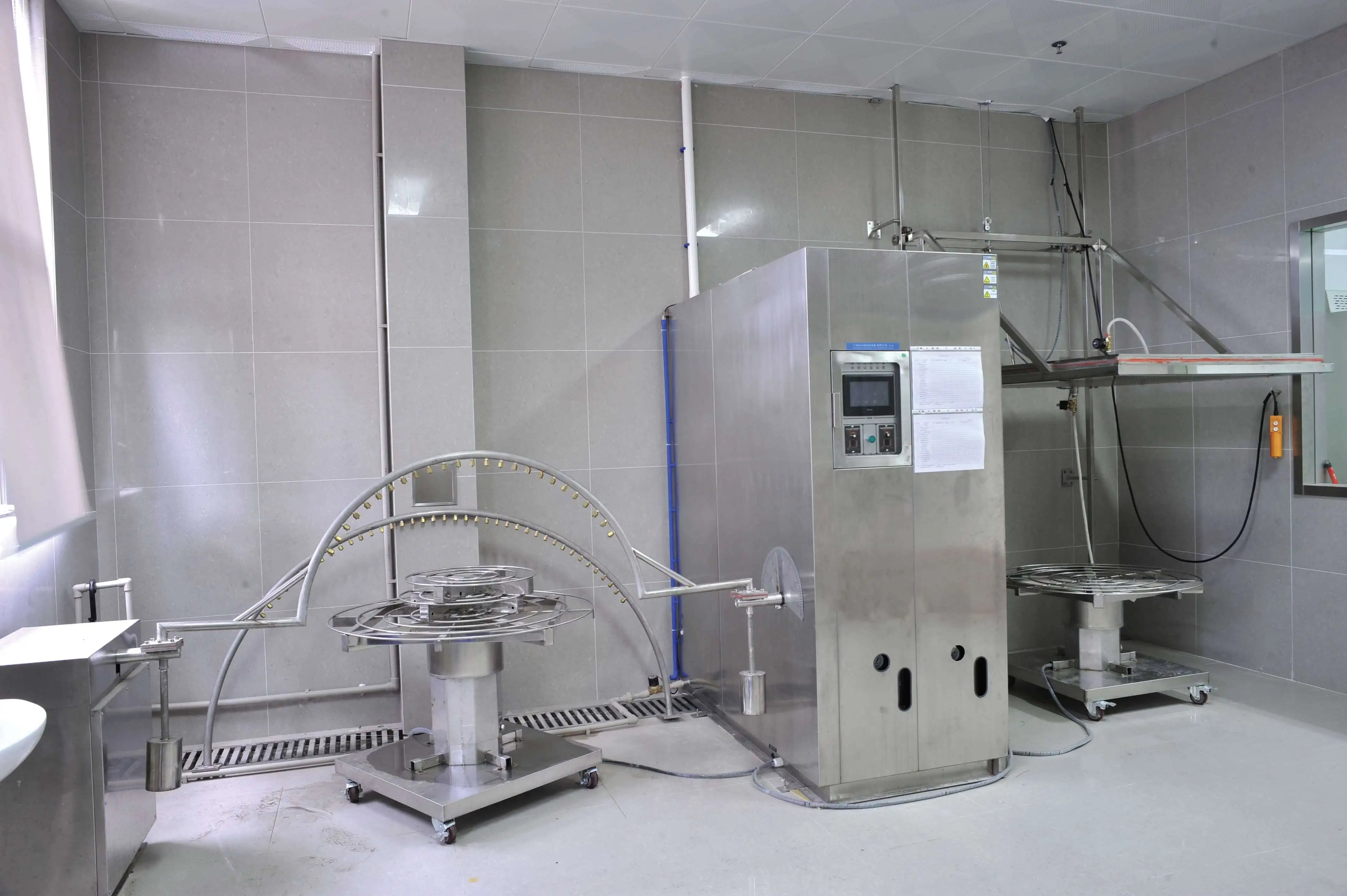 Industrial or laboratory setting with large metallic equipment and tiled walls.
